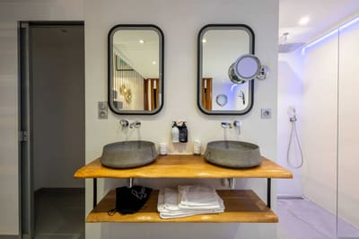 Salle de bain moderne avec double douche et jacuzzi dans la Suite Santorin